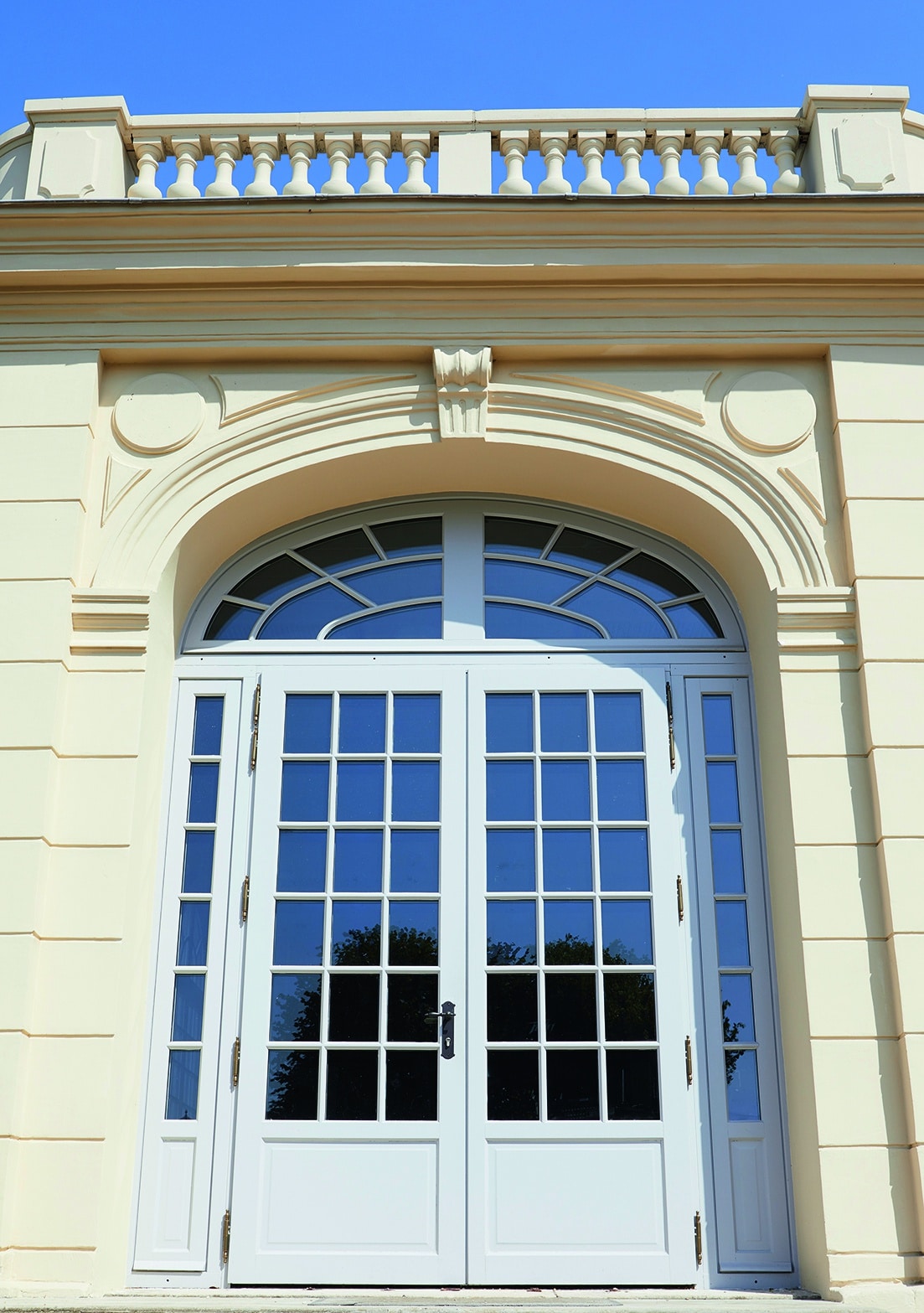 An exterior view of the wood door entry of a French mansion.