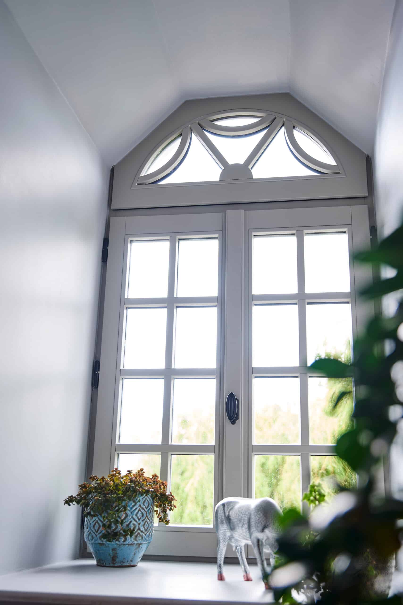 The interior view of a white custom wood window in a country house.