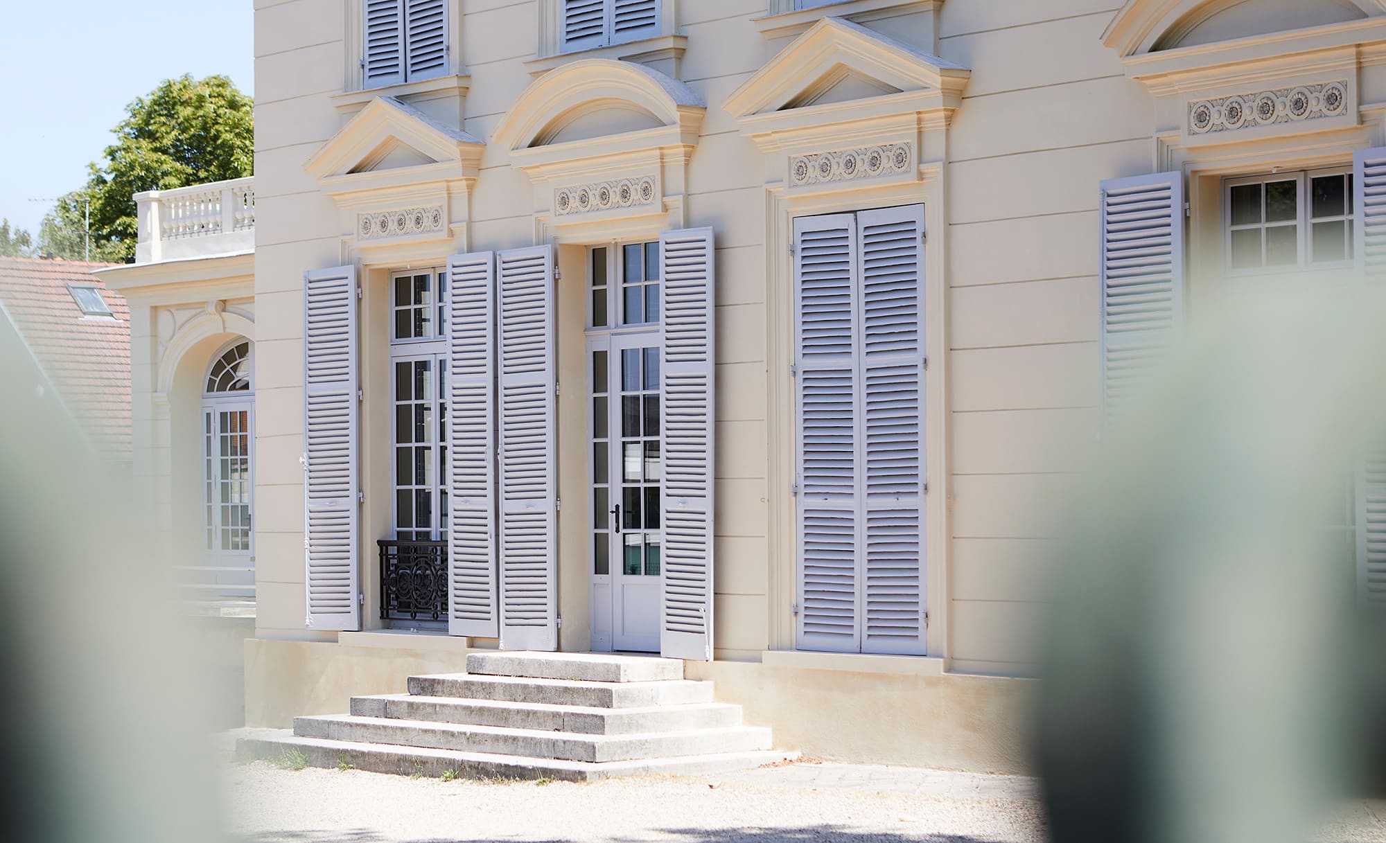 An exterior view of a French mansion and a side door entry.