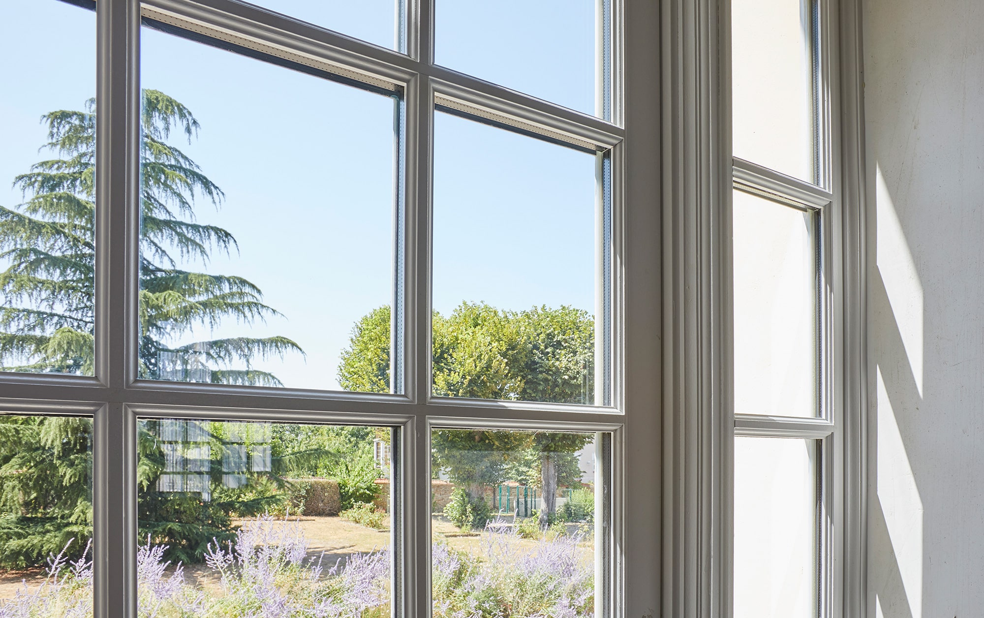 The interior of a French mansion showcasing the ornamental details of a custom wooden window.