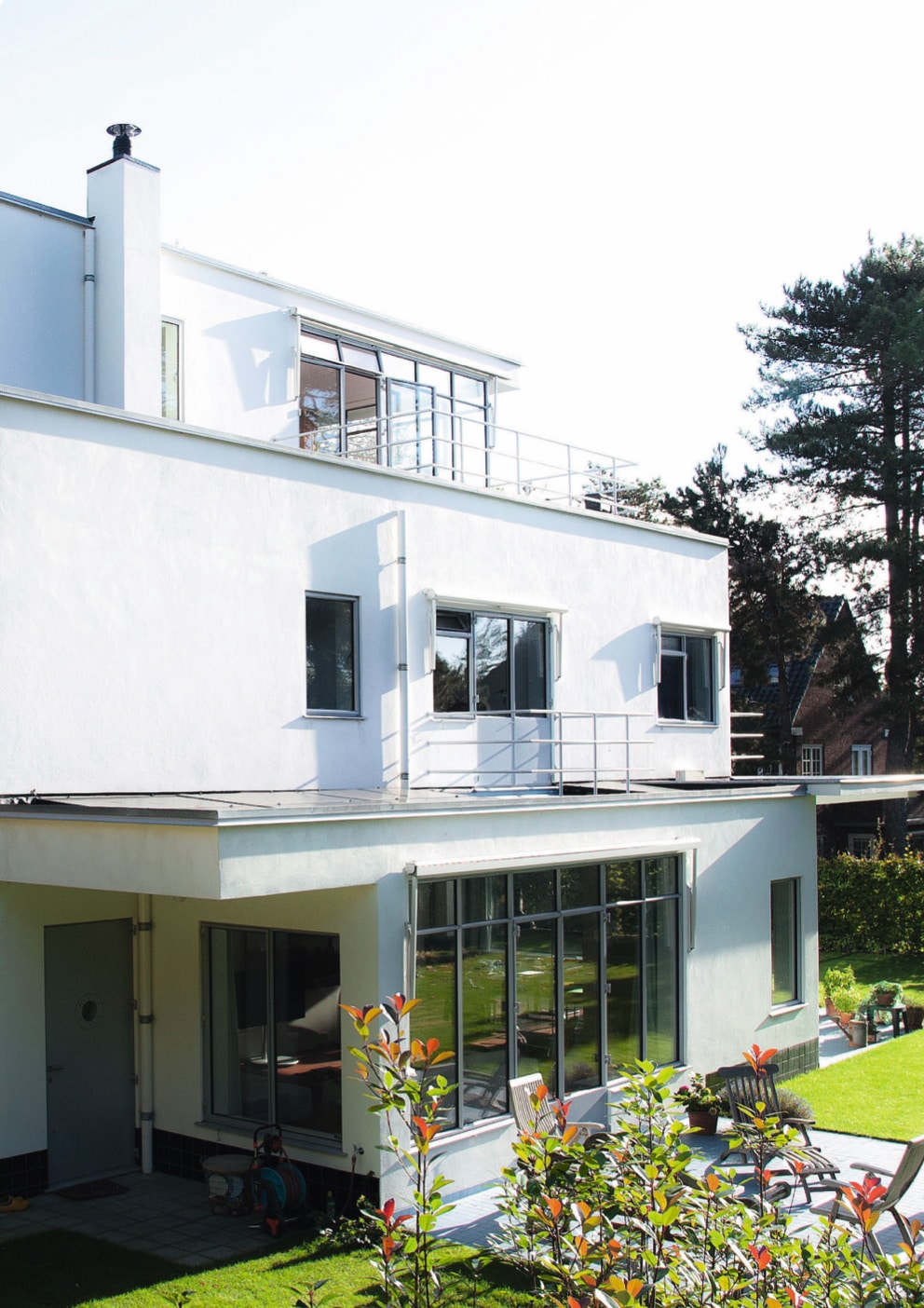 An exterior view of a white three-story residence with steel windows.