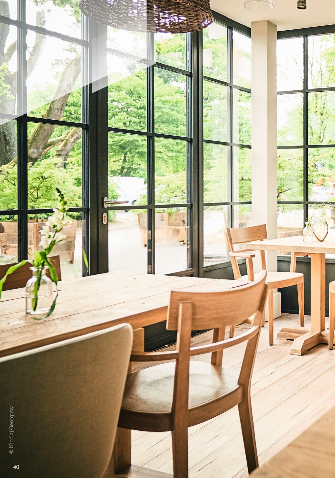 The interior of a restaurant dining room showcasing a wall of steel windows and doors.