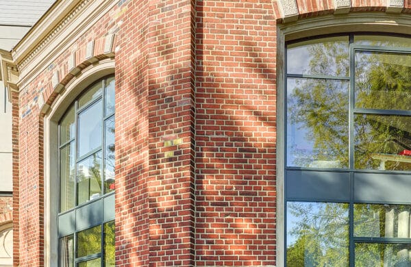 An exterior view of a brick building with banks of steel windows.