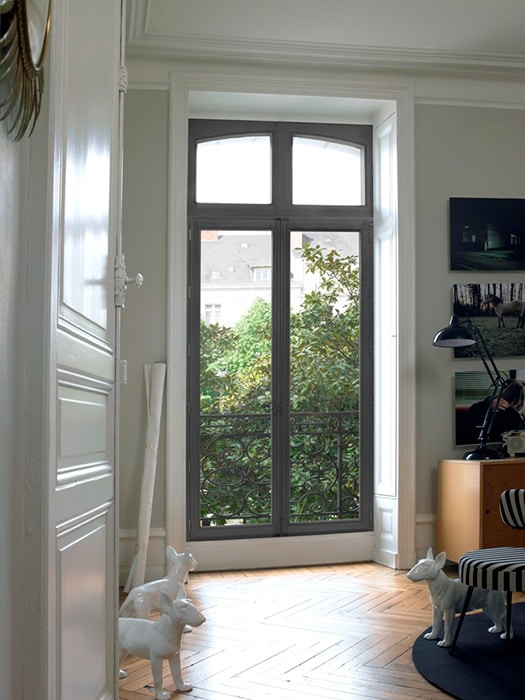 The interior of an apartment showcasing the ornamental details of a steel window.
