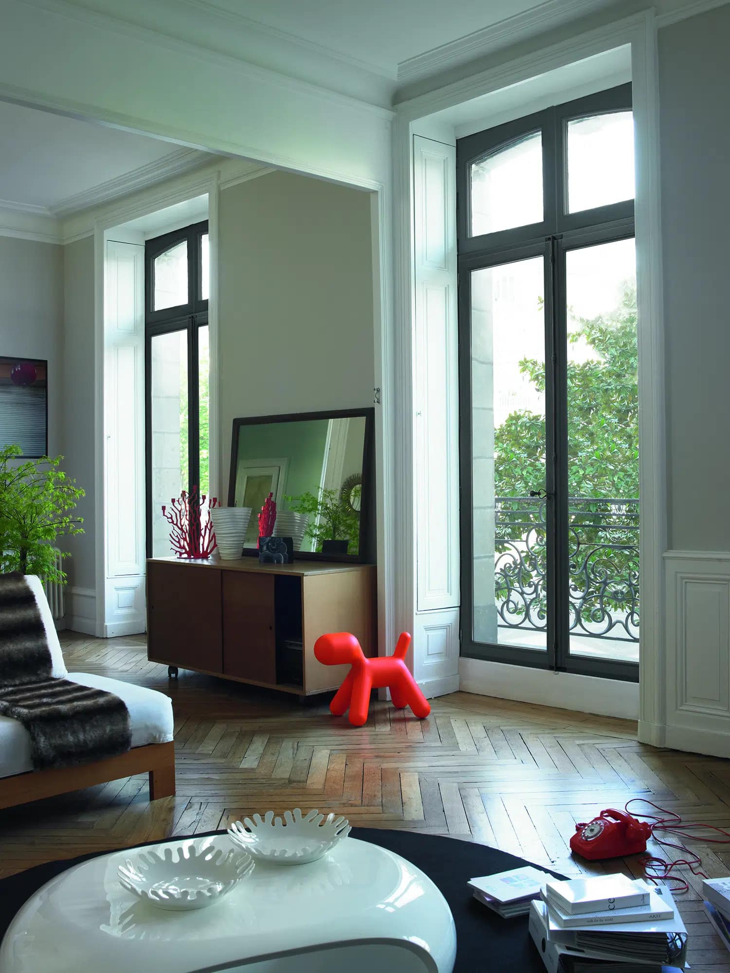 The interior view of a living room showcasing floor to ceiling wood windows and doors.